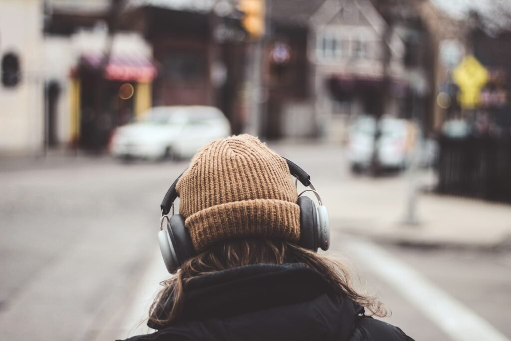 Person in a knit cap wearing headphones outdoors