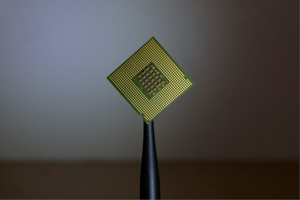 A computer processor held by black tweezers